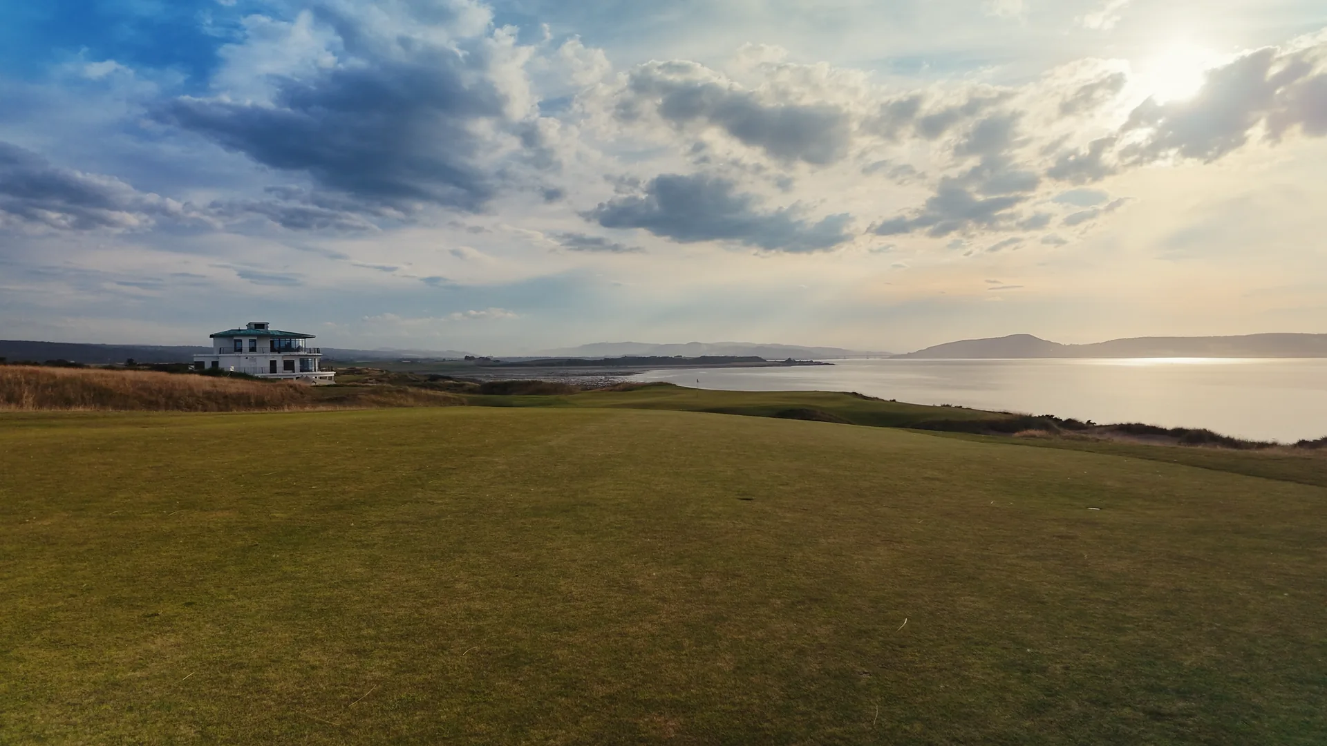 The clubhouse and coastline in the evening light
